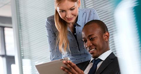 Man and woman in channel marketing looking at a tablet device together at work